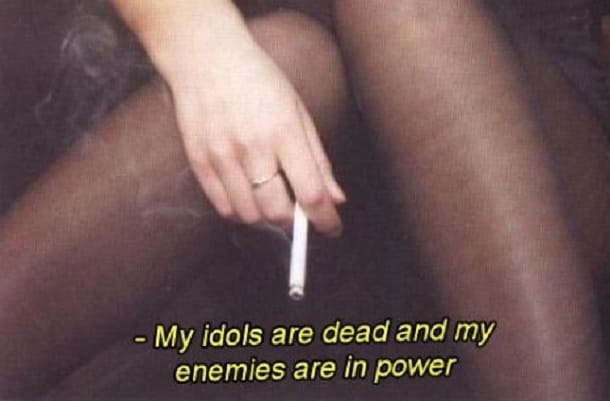 A woman's crossed legs. Her hand, dangling a lit cigarette. The caption reads, "My idols are dead e ad and my enemies are in power."