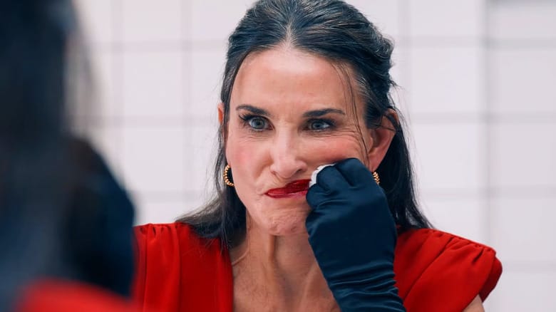 A woman in a red dress, looking at her reflection in a bathroom mirror, smearing her lipstick.