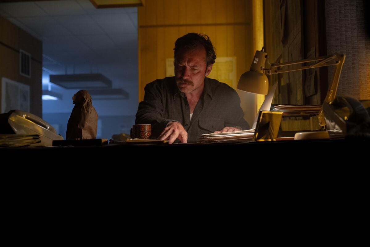 A man looking through documents on his desk.