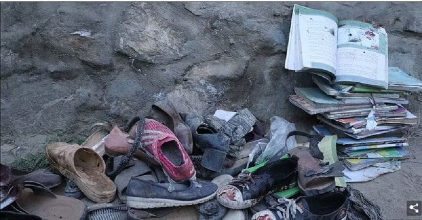 A pile of shoes and schoolbooks stained with blood.